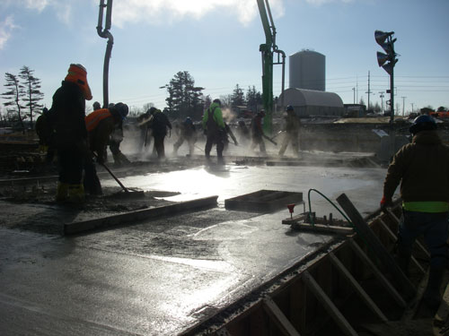 <b>Steam rises from a newly poured concrete slab at an industrial construction site. Carl A. Nelson & Company self-performs about 40 percent of contracted work annually, including substructure and superstructure concrete.</b>